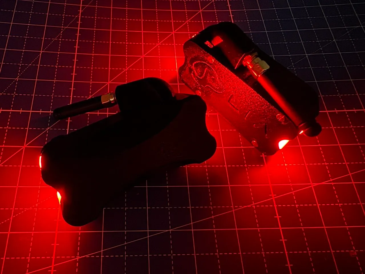 Two assembled enclosures glowing red in a dark room