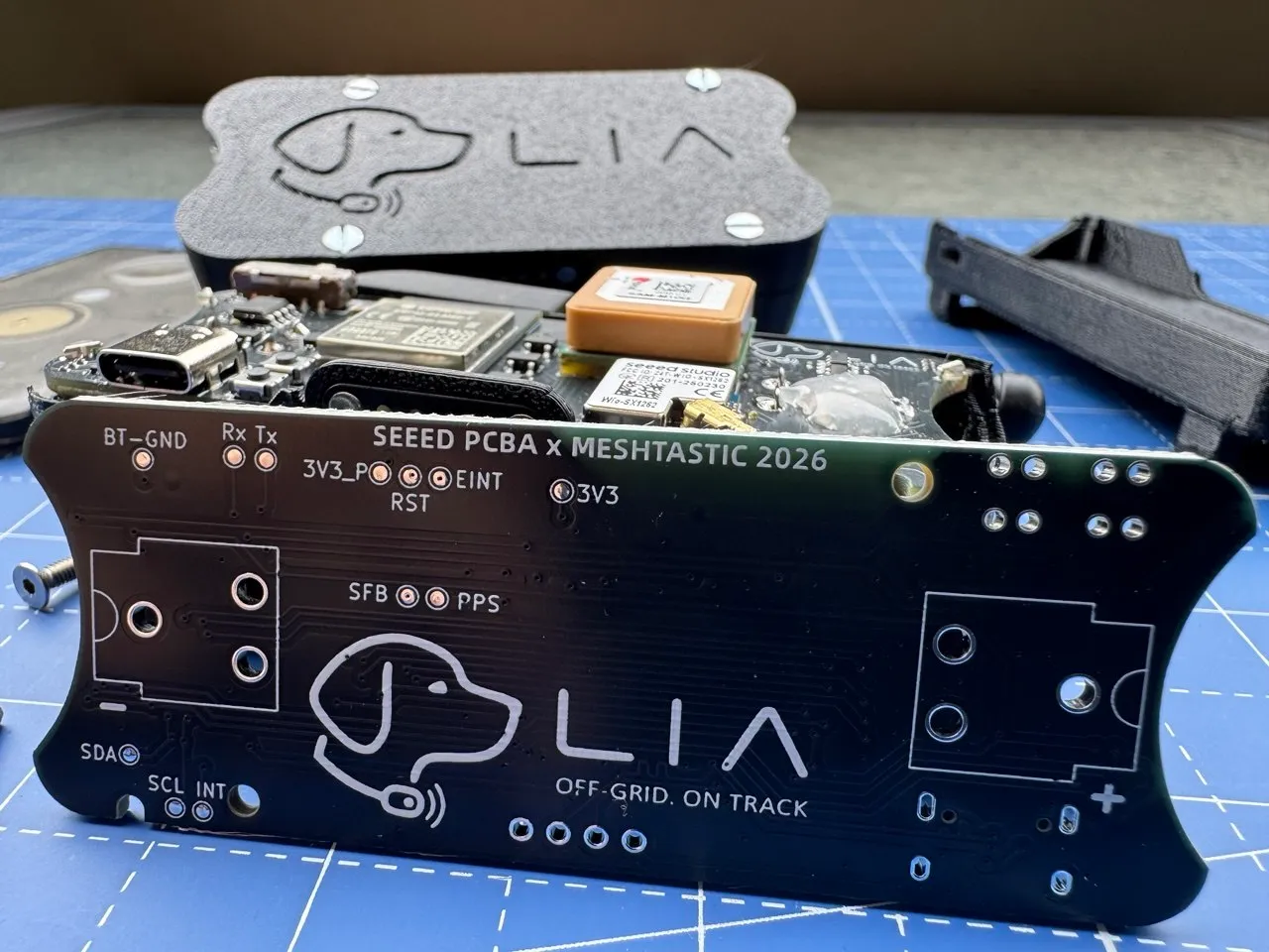 Open LIA board next to a 3D-printed enclosure shell, showing the board's test points and GNSS module