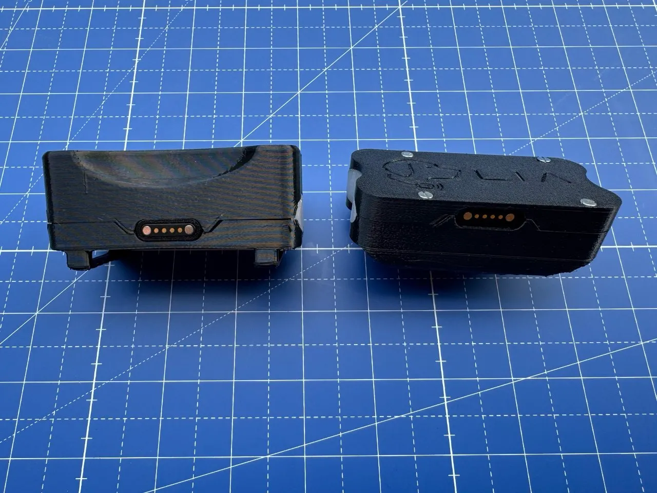 Two enclosures compared side-on, showing the magnetic pogo charging contacts