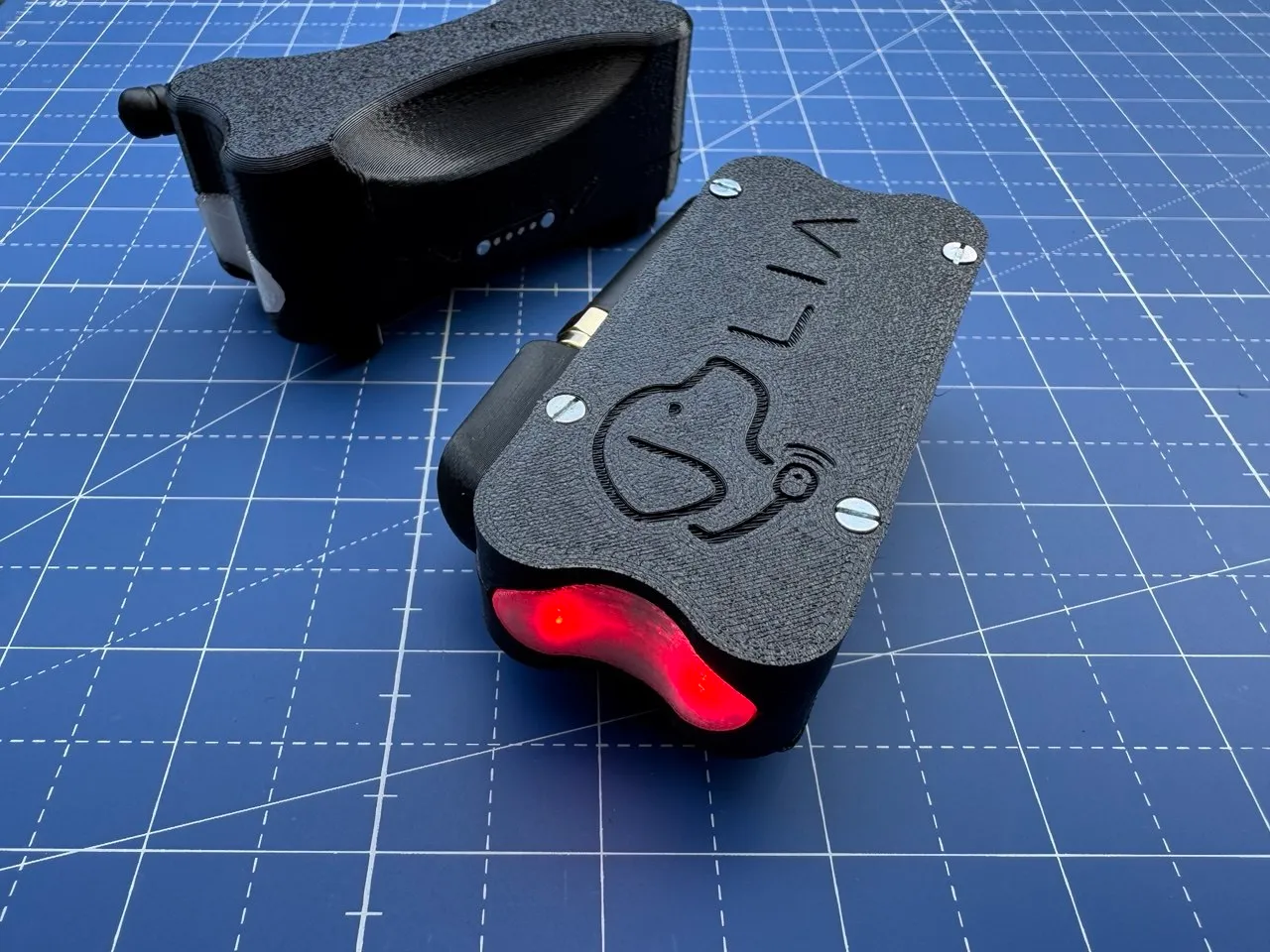 Detachable collar clip next to the assembled enclosure, status LED lit red