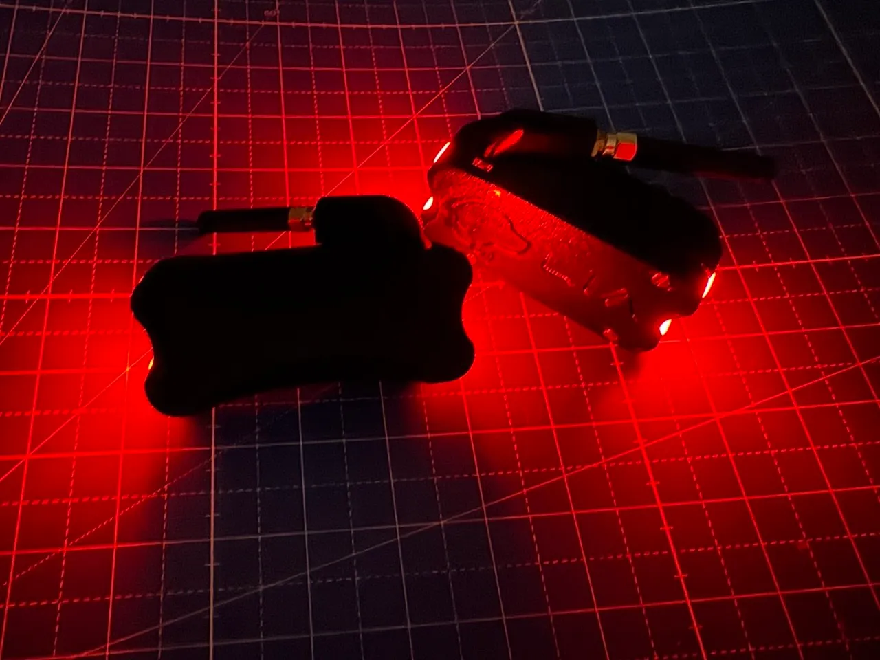 Two enclosures glowing red in the dark, angled comparison